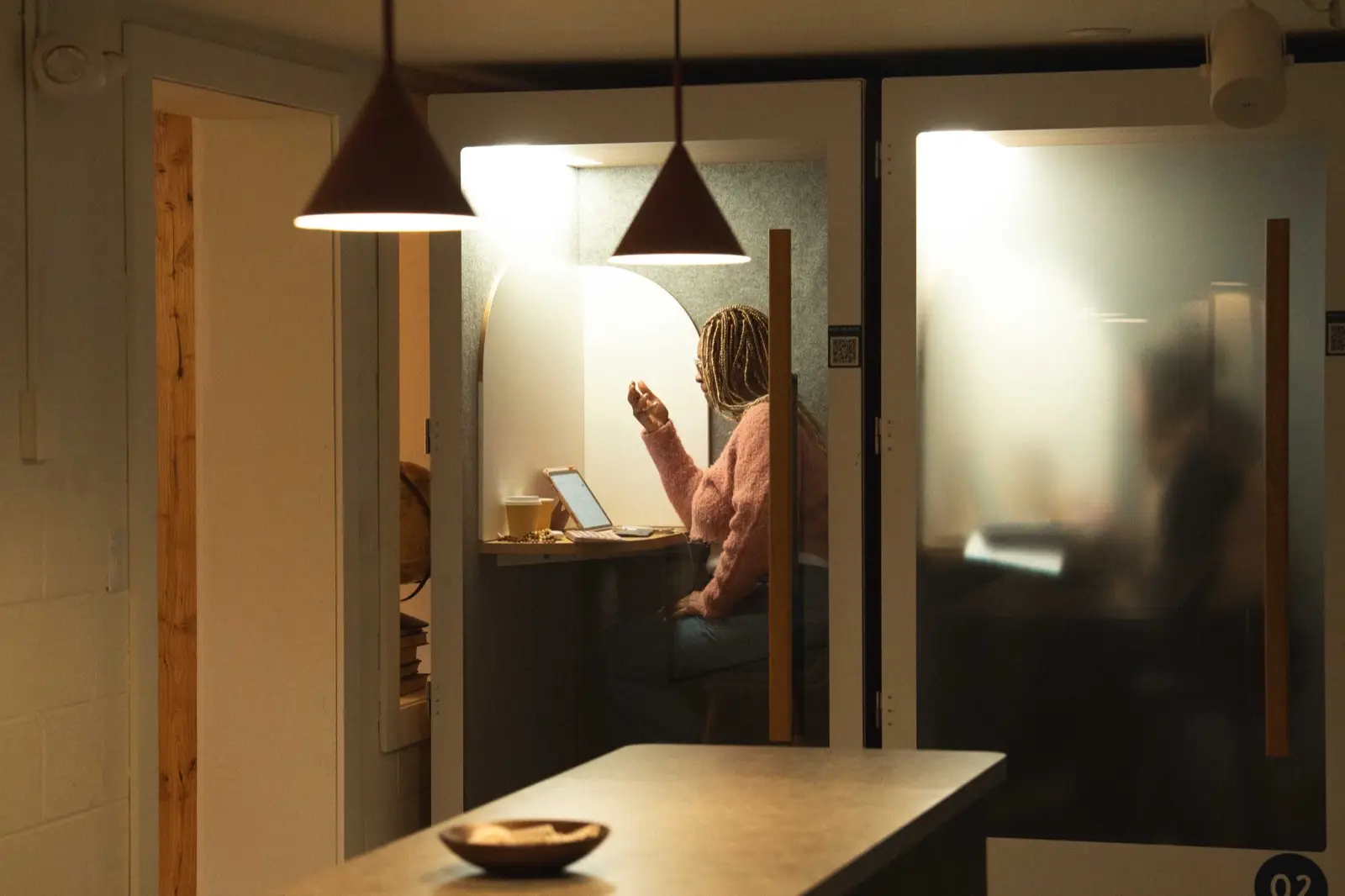 A member on a call inside a glass phone booth