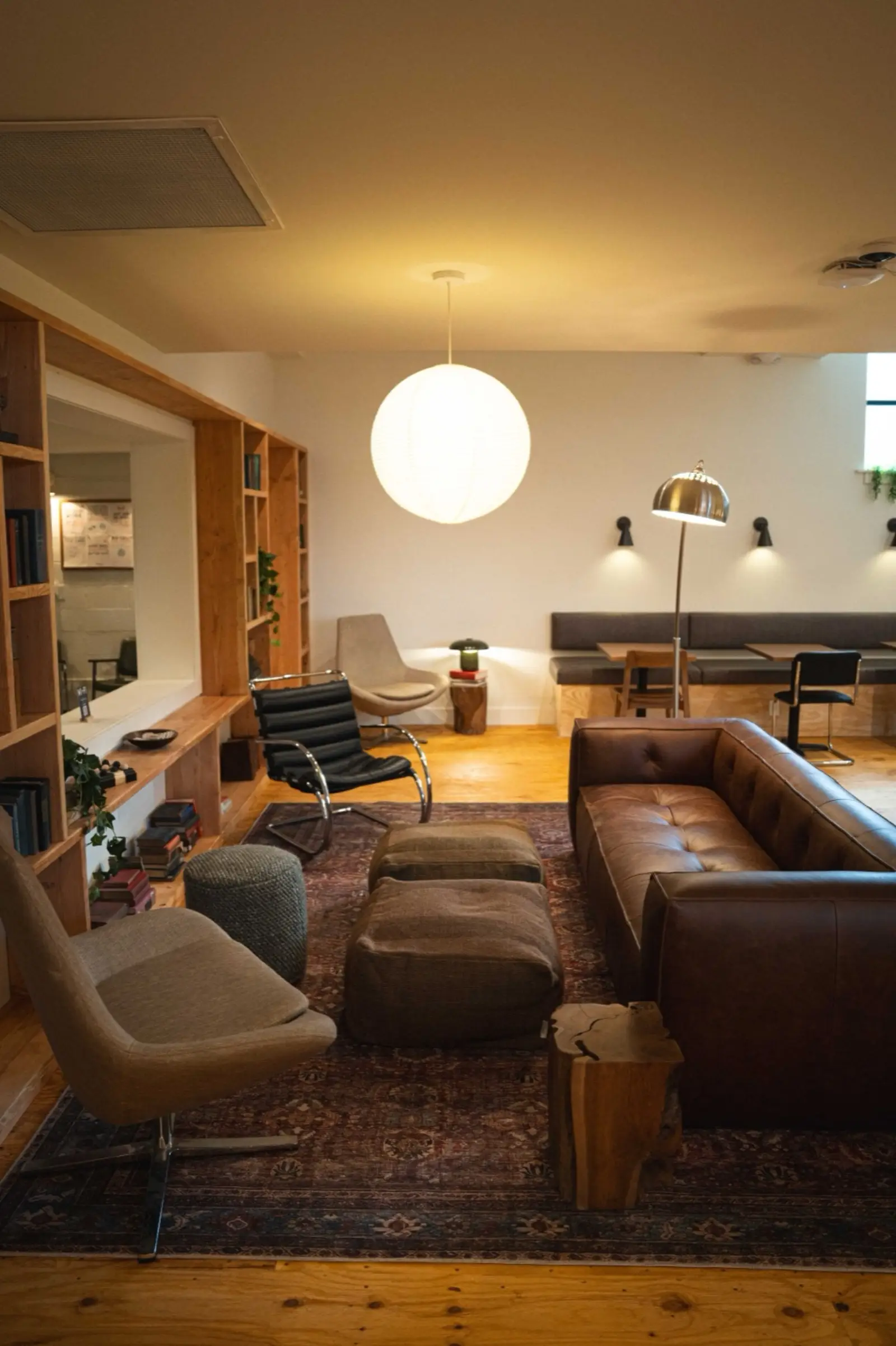 The lounge: leather sofas, armchairs and a rug under a paper lantern