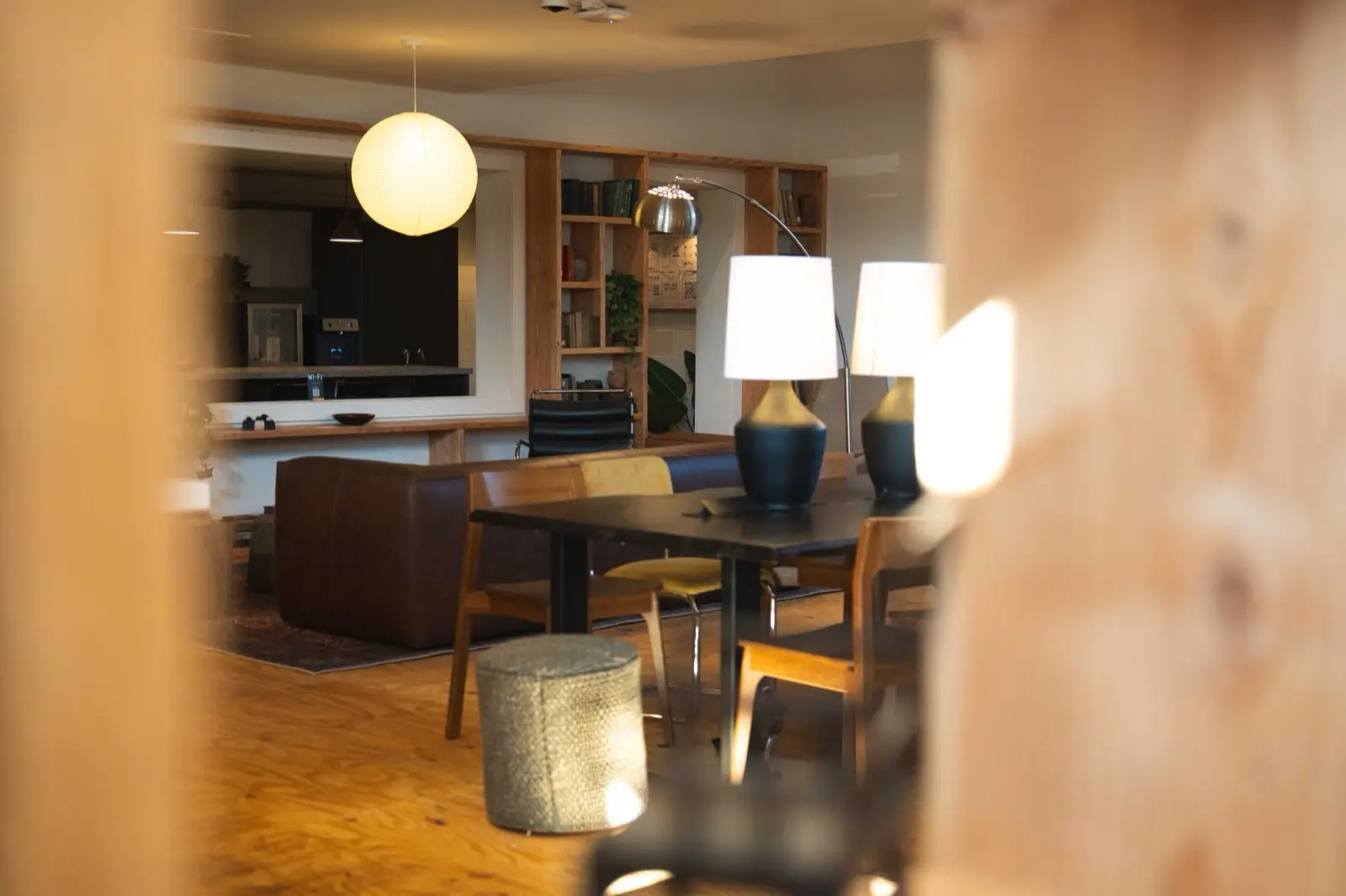 The club seen through a wood bookshelf, lamps and tables beyond